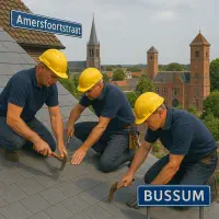 “Dakdekkers op leien schilddak in Bussum aan de Amersfoortsestraat met zicht op de Sint-Vituskerk en het Raadhuis.”